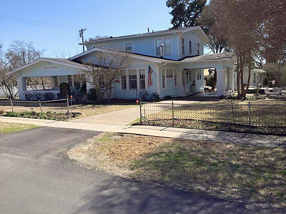 A two-story home with a covered porch and a new roof
